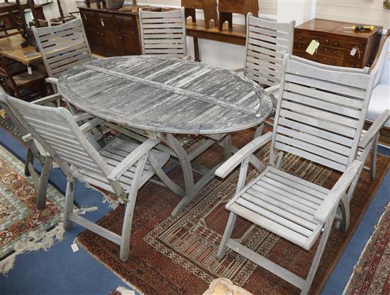 A teak garden table and seven reclining armchairs Table 200 x 110cm